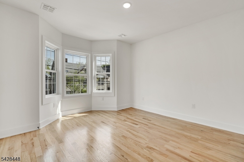 196 Taylor Street Orange, NJ 07050 - Photo 12 of 31 an empty room with wooden floor and windows