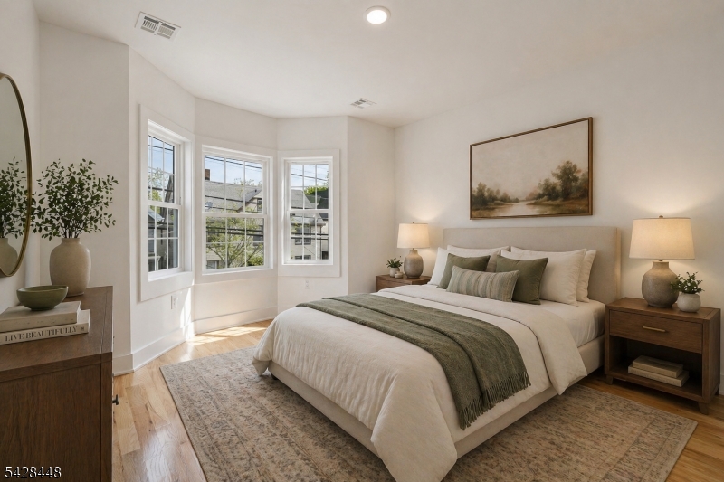 196 Taylor Street Orange, NJ 07050 - Photo 13 of 31 a bedroom with a large bed and a potted plant