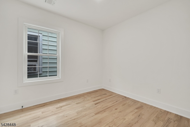 196 Taylor Street Orange, NJ 07050 - Photo 15 of 31 a view of empty room with wooden floor and fan