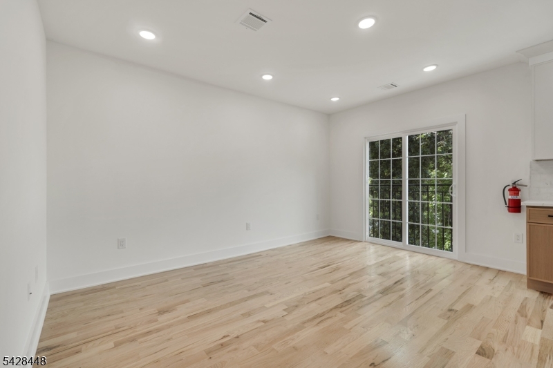 196 Taylor Street Orange, NJ 07050 - Photo 17 of 31 an empty room with wooden floor and windows