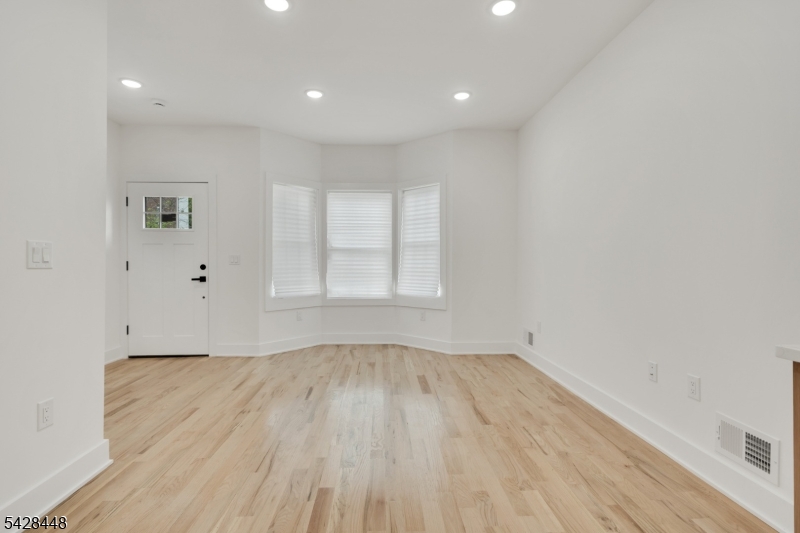 196 Taylor Street Orange, NJ 07050 - Photo 2 of 31 an empty room with wooden floor and windows
