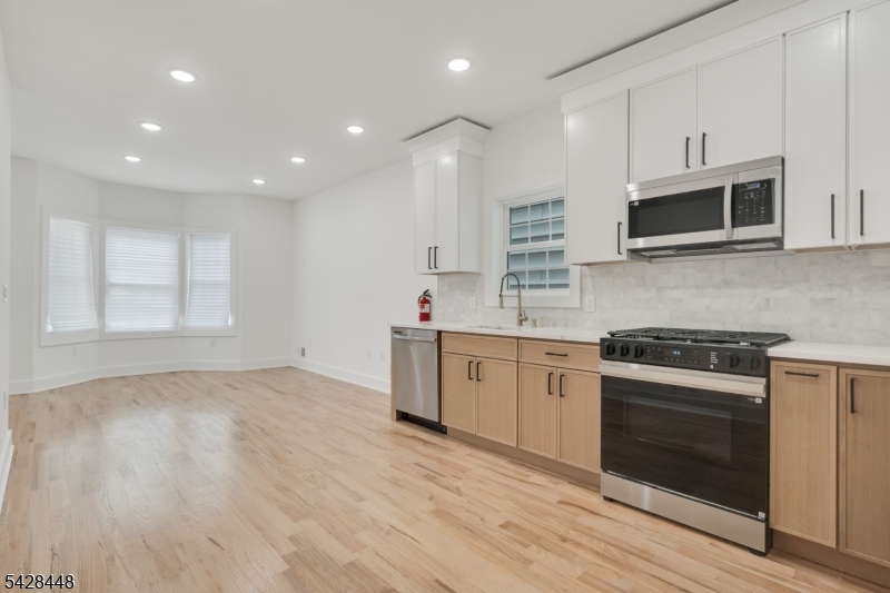 196 Taylor Street Orange, NJ 07050 - Photo 4 of 31 a kitchen with stainless steel appliances granite countertop a stove and a microwave