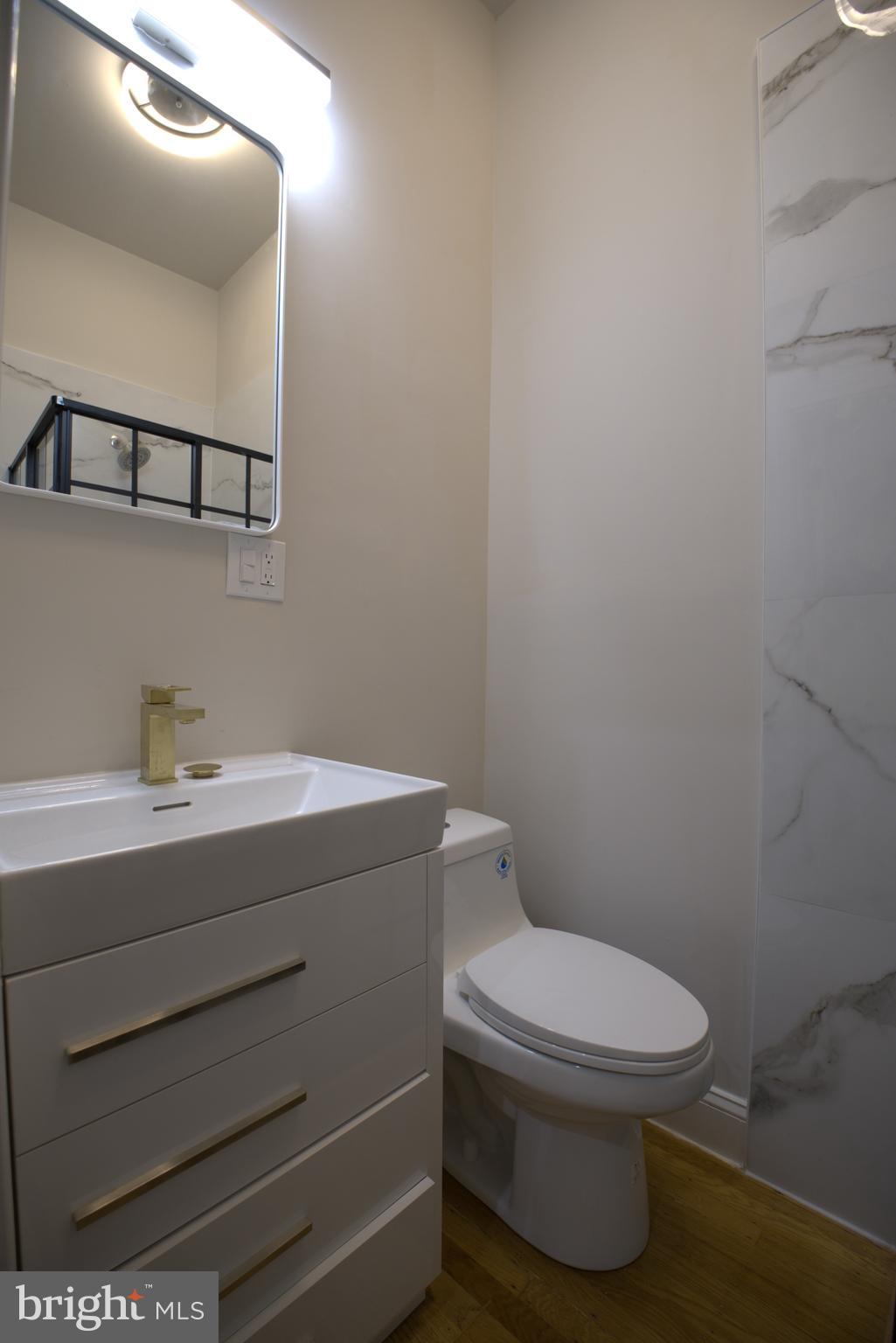 333 South 21st Street, Unit 1F Philadelphia, PA 19103 - Photo 8 of 15 a bathroom with a toilet a sink and mirror