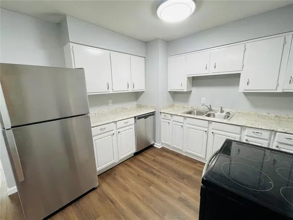 a kitchen with a refrigerator sink and cabinets