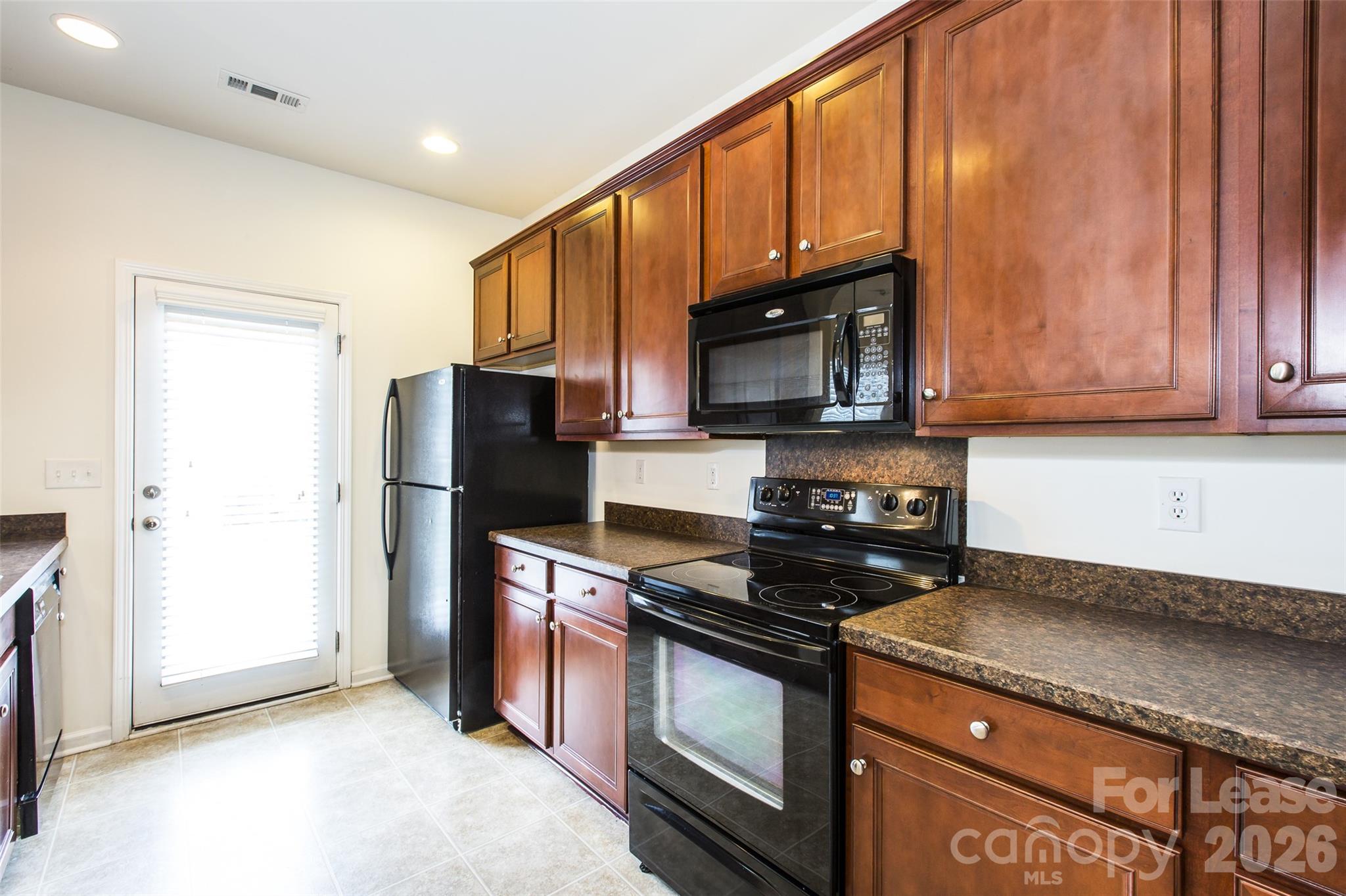 13422 Erwin Road Charlotte, NC 28273 - Photo 13 of 35 a kitchen with granite countertop wooden cabinets and a stove top oven
