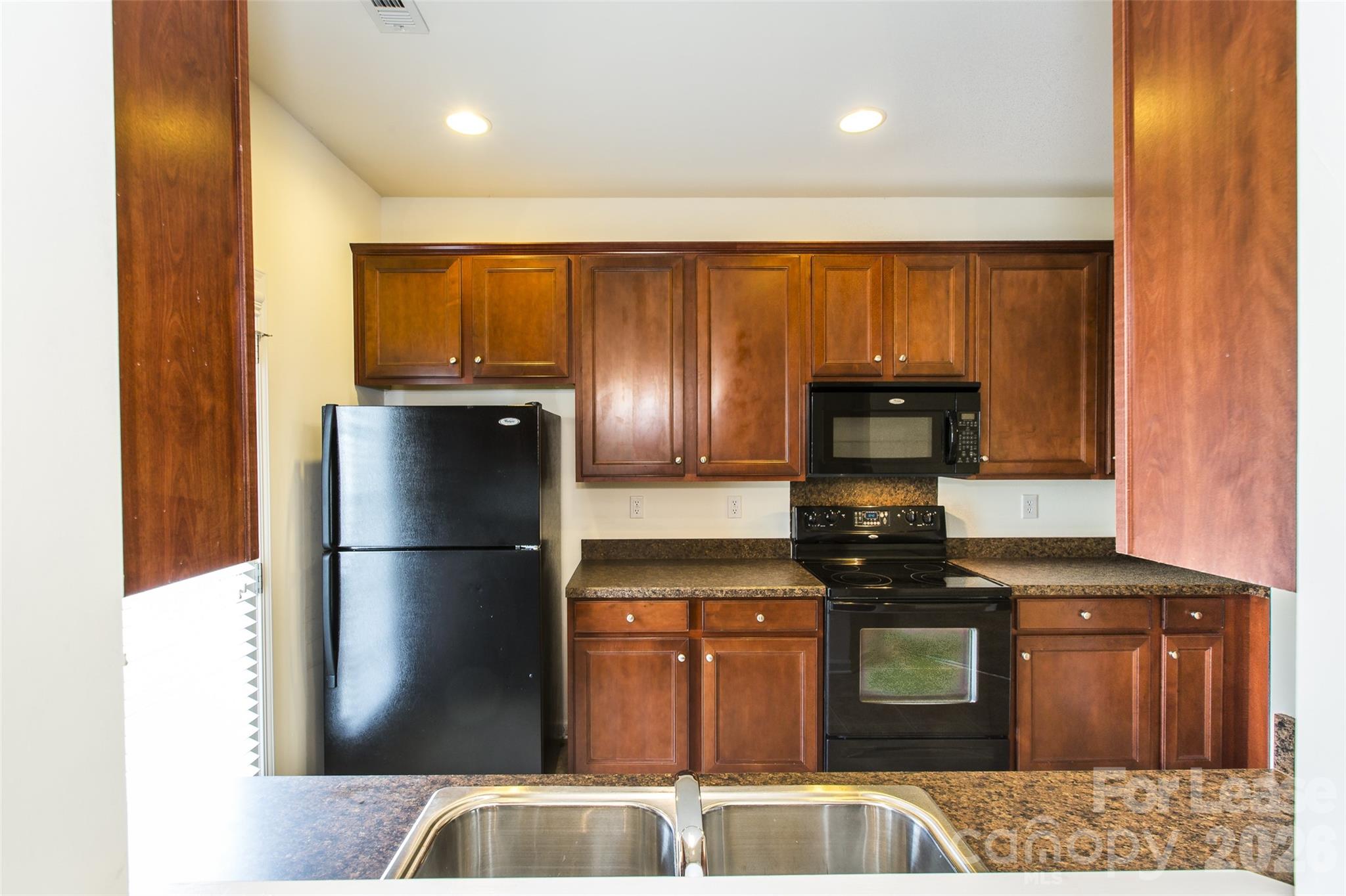 13422 Erwin Road Charlotte, NC 28273 - Photo 17 of 35 a kitchen with a refrigerator and a stove top oven