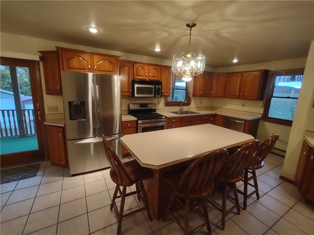 4641 Ellwood Road New Castle, PA 16101 - Photo 5 of 26 a kitchen with stainless steel appliances a table chairs refrigerator and microwave