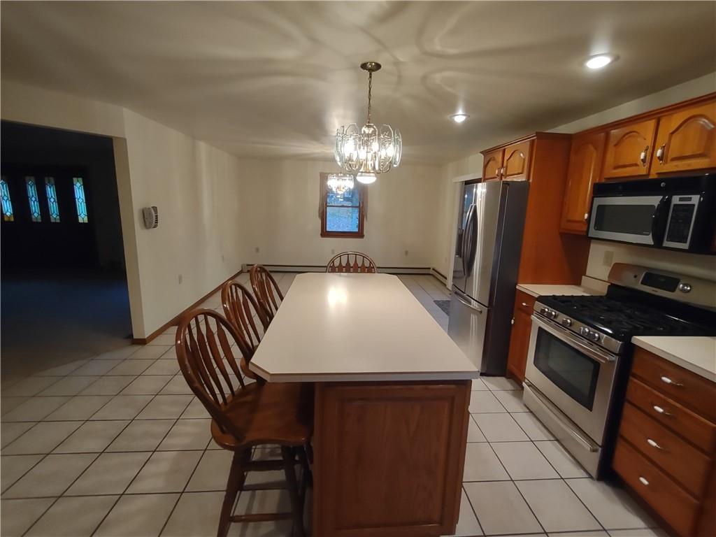 4641 Ellwood Road New Castle, PA 16101 - Photo 7 of 26 a kitchen with stainless steel appliances granite countertop a sink dishwasher a stove a refrigerator and a dining table with wooden floor