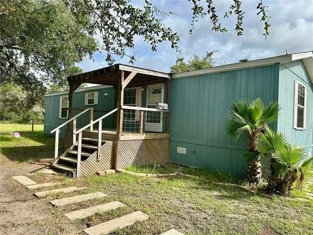 a backyard of a house with table and chairs