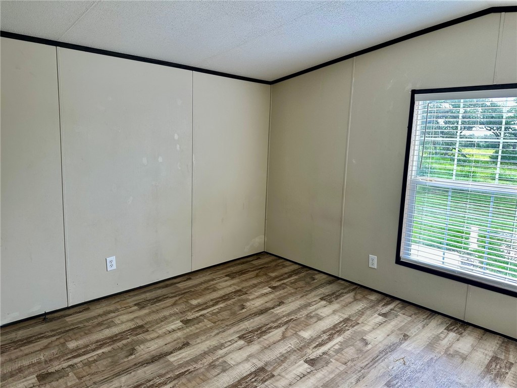1522 16th Street, Unit 6 Rockport, TX 78382 - Photo 11 of 12 a view of an empty room with wooden floor and a window