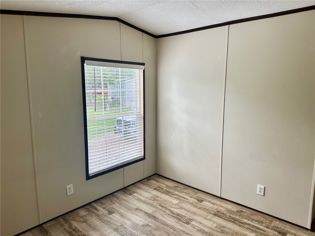 1522 16th Street, Unit 6 Rockport, TX 78382 - Photo 12 of 12 a view of an empty room with window and wooden floor