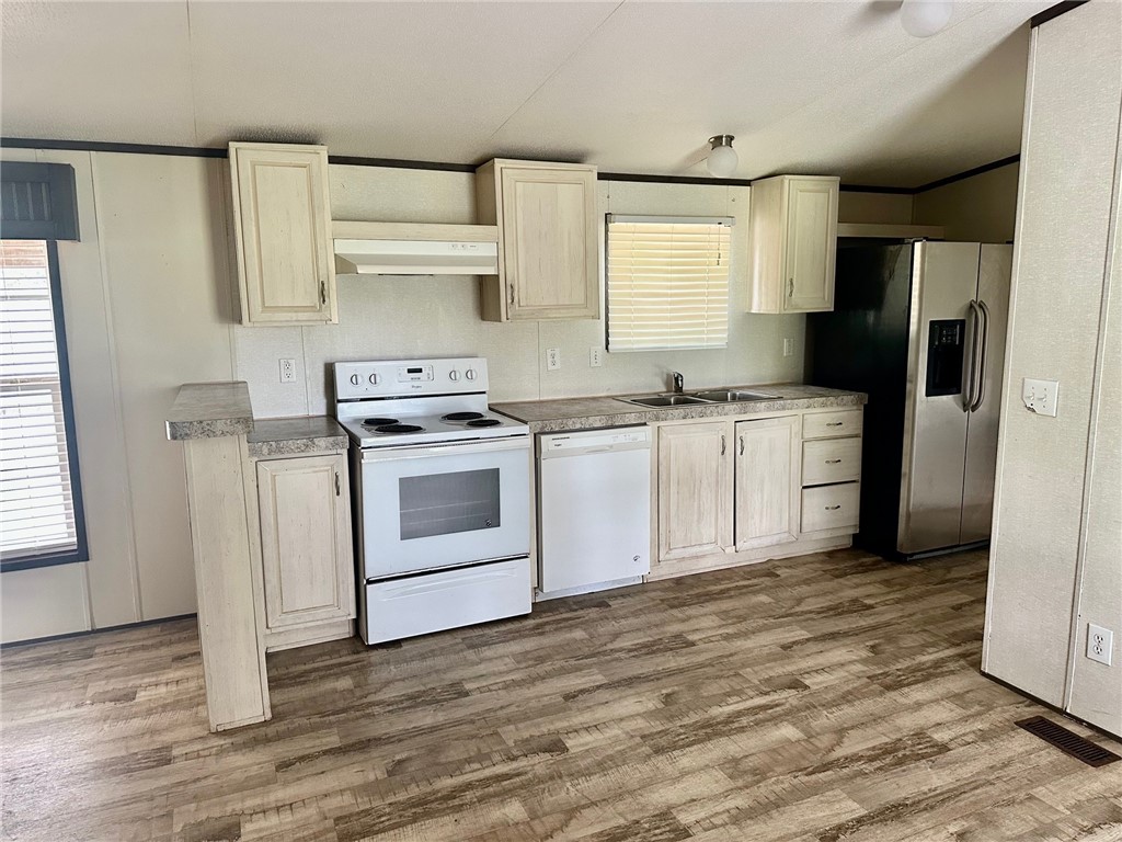 1522 16th Street, Unit 6 Rockport, TX 78382 - Photo 5 of 12 a kitchen with stainless steel appliances a stove a sink and a refrigerator