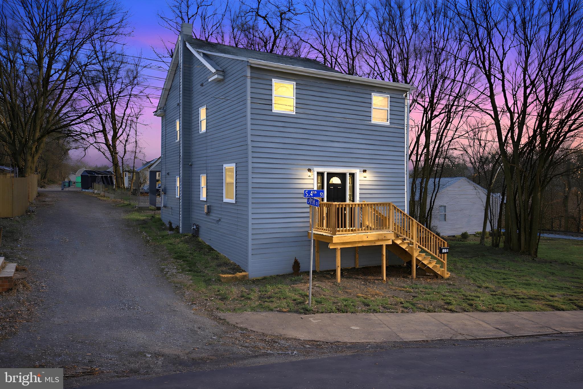 a view of a house with a yard and wooden fence