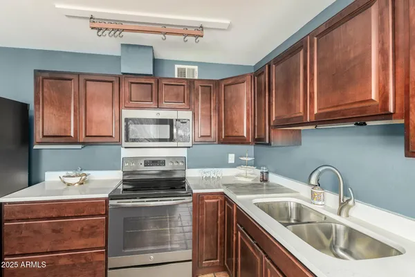 a kitchen with stainless steel appliances granite countertop a sink stove and refrigerator