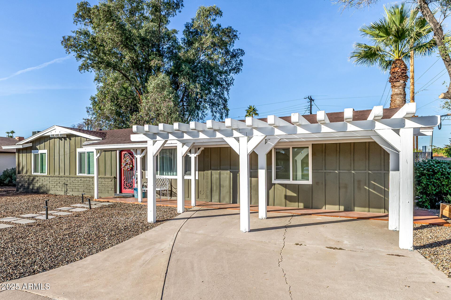 2302 West Berridge Lane Phoenix, AZ 85015 - Photo 5 of 40 a view of a white house with large trees and plants
