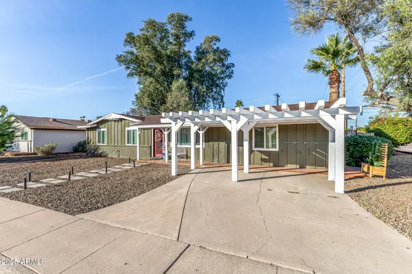 a front view of a house with a yard and potted plants