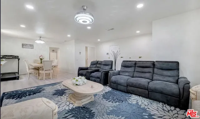a living room with furniture a wooden floor and chandelier
