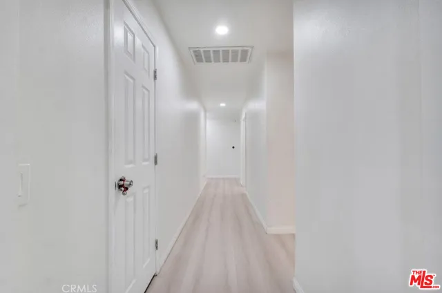 a view of a hallway with wooden floor