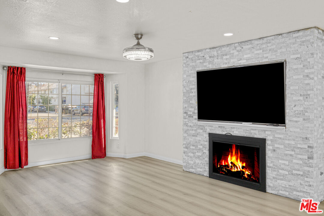 7701 Baird Avenue Reseda, CA 91335 - Photo 3 of 21 a view of an empty room with wooden floor fireplace and a window