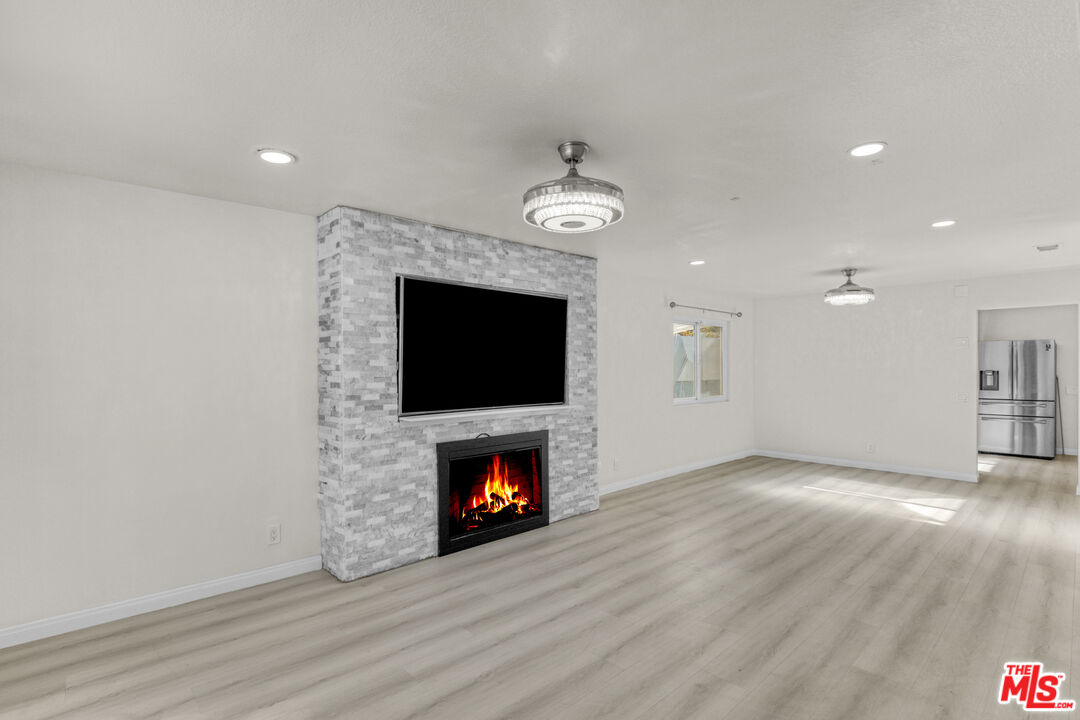 7701 Baird Avenue Reseda, CA 91335 - Photo 4 of 21 a view of an empty room with wooden floor fireplace and a window