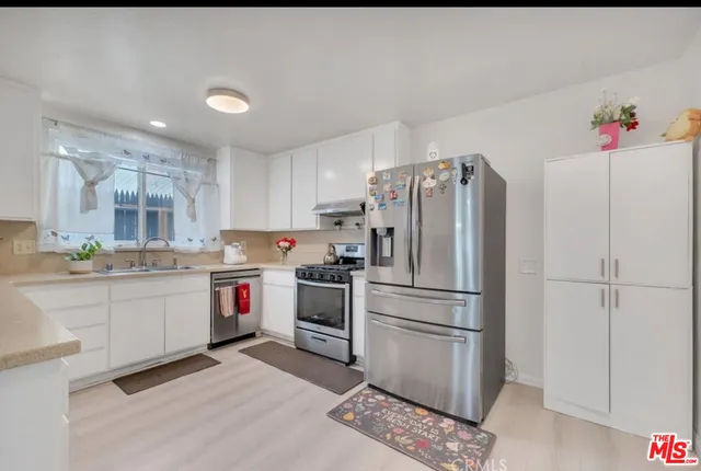 a kitchen with granite countertop stainless steel appliances and refrigerator
