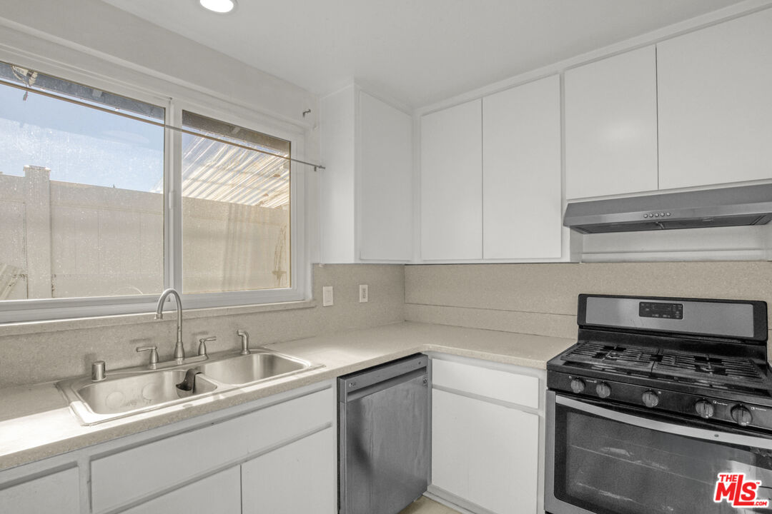 7701 Baird Avenue Reseda, CA 91335 - Photo 7 of 21 a kitchen with a sink stove top oven and cabinets