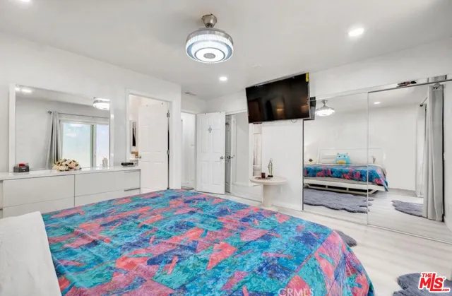 a bedroom with a bed and a flat screen tv