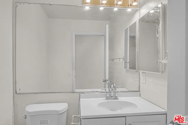 a bathroom with a sink vanity mirror and toilet
