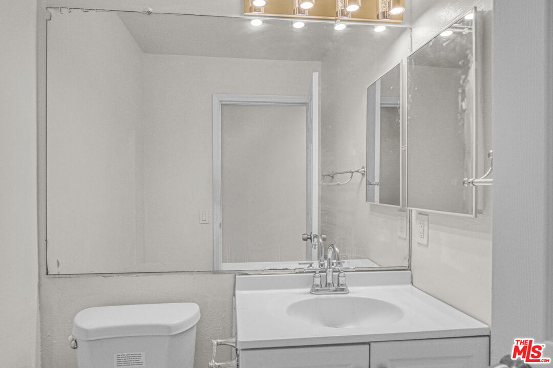 7701 Baird Avenue Reseda, CA 91335 - Photo 10 of 21 a bathroom with a sink vanity mirror and toilet