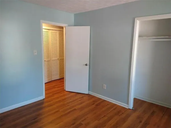 an empty room with wooden floor and entrance