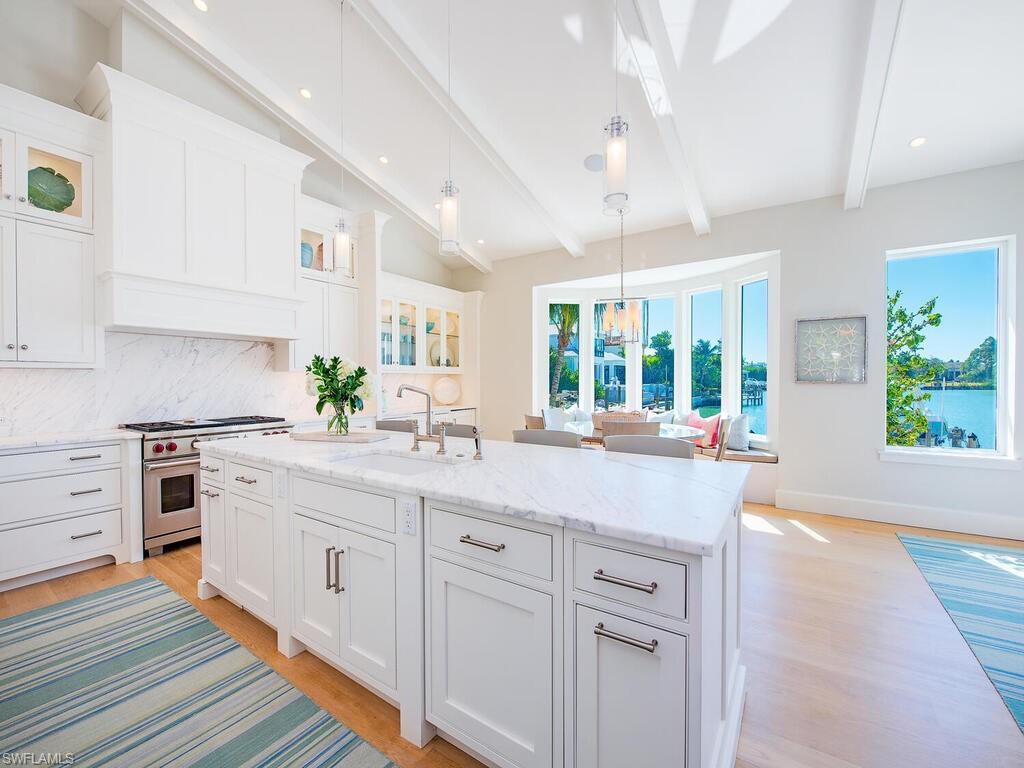 440 Springline Drive Naples, FL 34102 - Photo 11 of 28 a kitchen with white cabinets and wooden floor