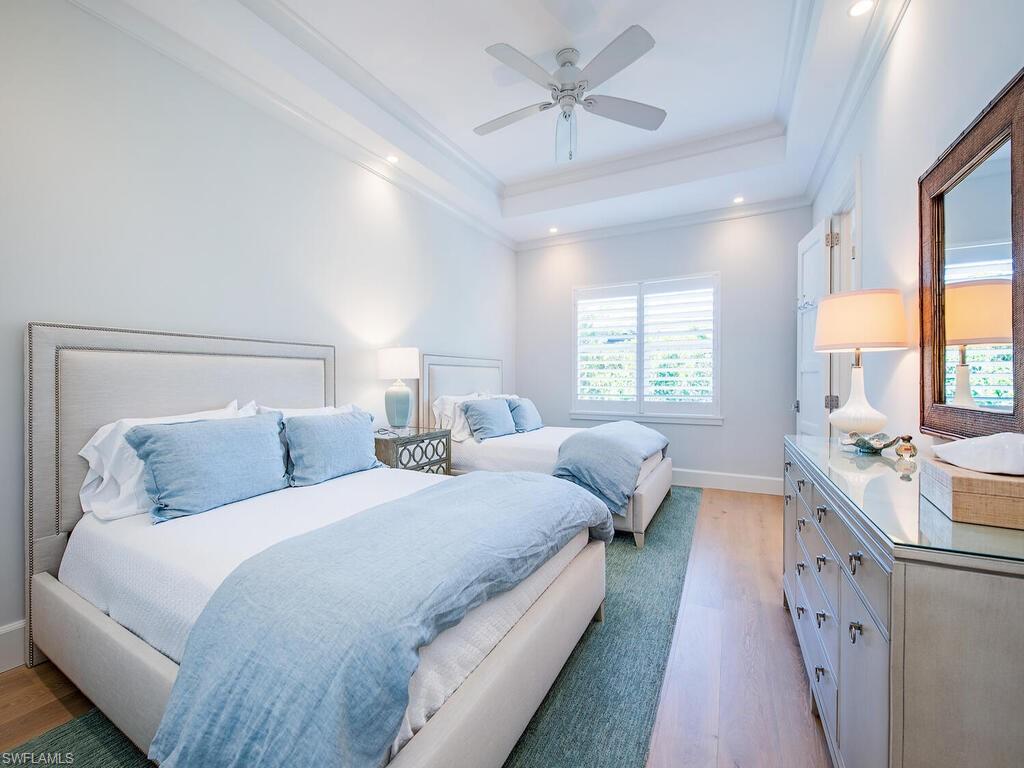 440 Springline Drive Naples, FL 34102 - Photo 22 of 28 a bedroom with two beds and a chandelier