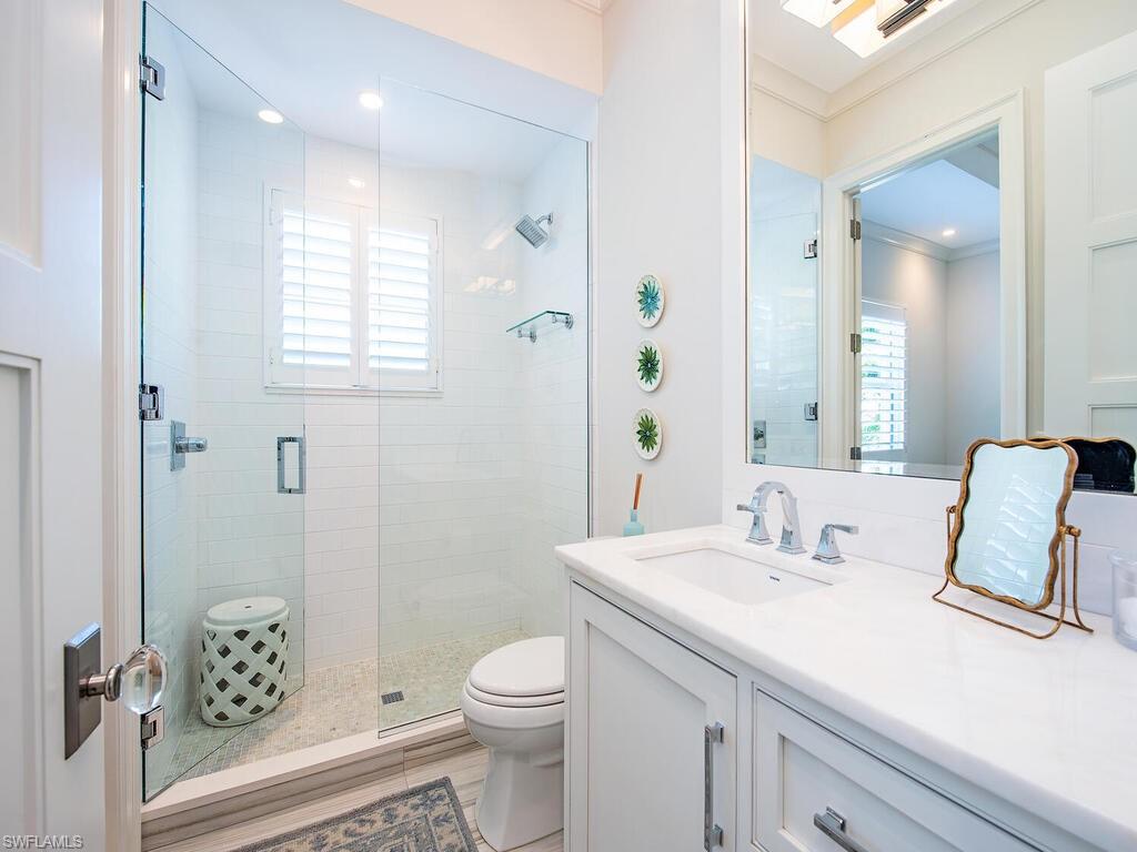 440 Springline Drive Naples, FL 34102 - Photo 23 of 28 a bathroom with a sink a toilet and shower