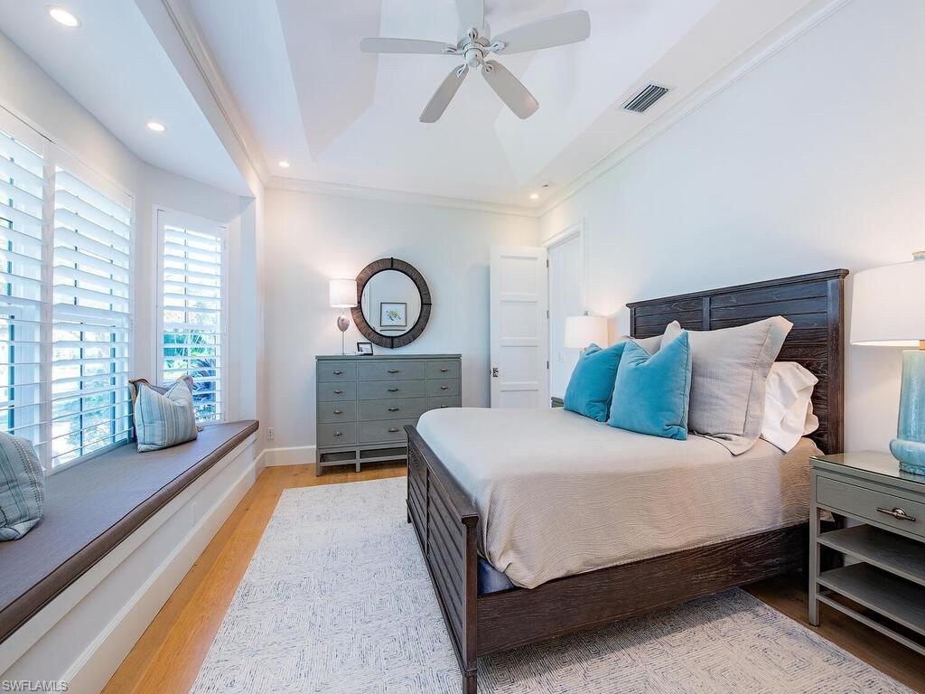 440 Springline Drive Naples, FL 34102 - Photo 24 of 28 a spacious bedroom with a bed a mirror and a large window