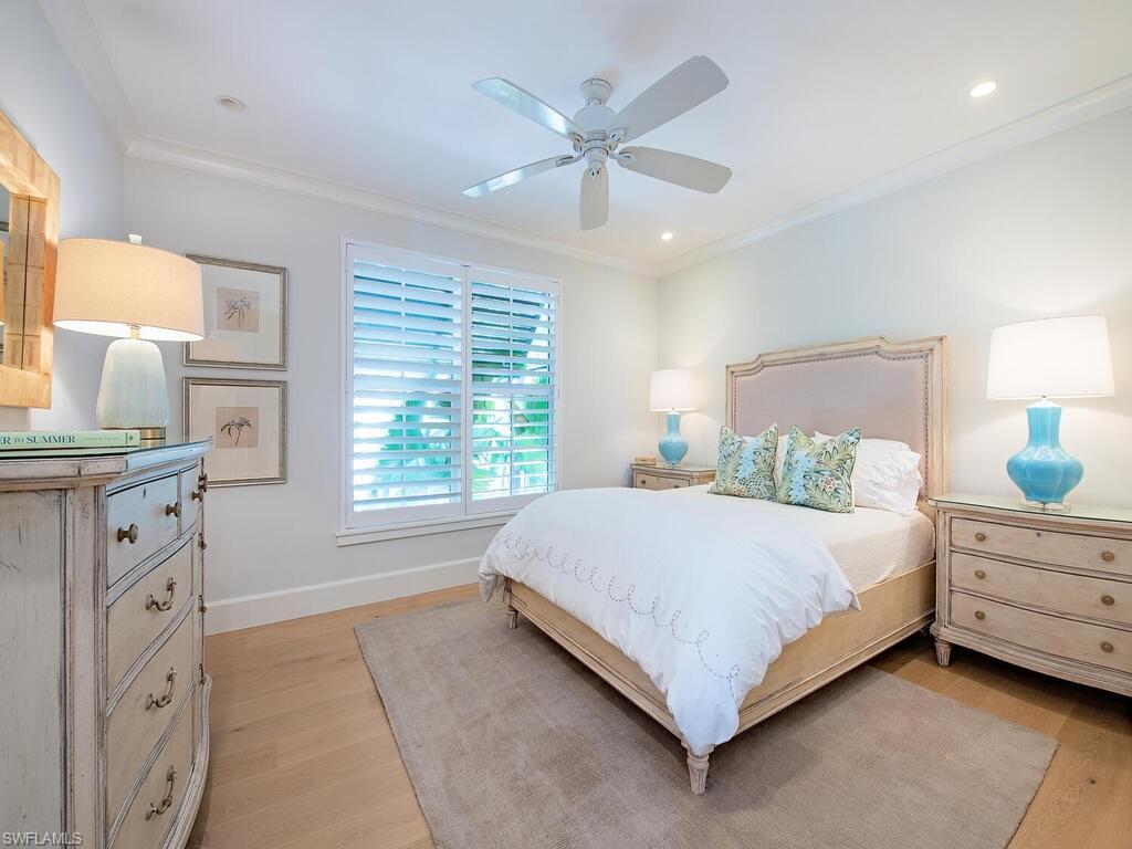 440 Springline Drive Naples, FL 34102 - Photo 25 of 28 a bedroom with a large bed and a chandelier