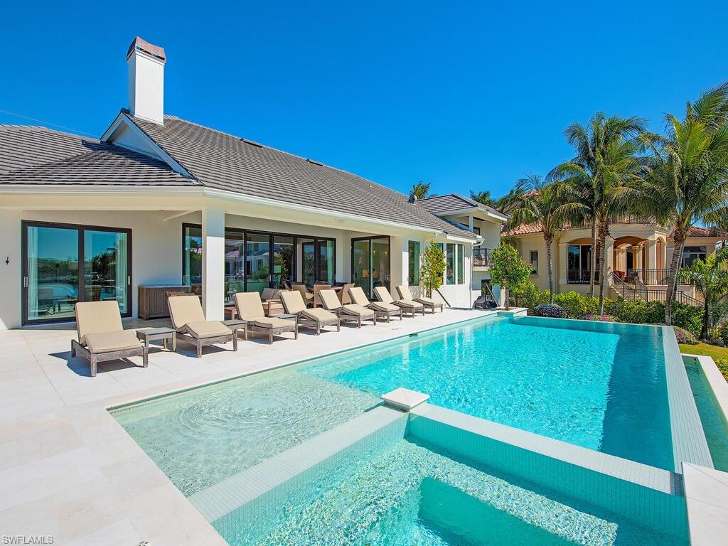 440 Springline Drive Naples, FL 34102 - Photo 4 of 28 a view of a house with pool porch and chairs