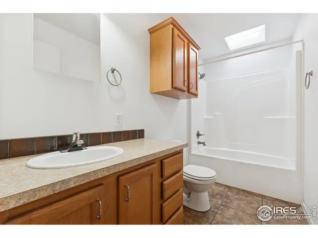 a bathroom with a granite countertop sink toilet and a mirror