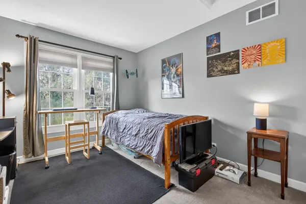 a bedroom with a bed and painting on the wall