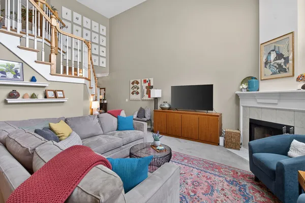 a living room with furniture a fireplace and a large window