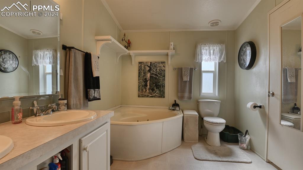 34475 East Jones Road Yoder, CO 80864 - Photo 14 of 31 a bathroom with a granite countertop sink mirror vanity bathtub and a toilet