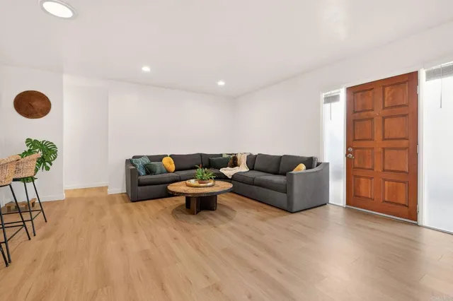 a living room with furniture and a wooden floor