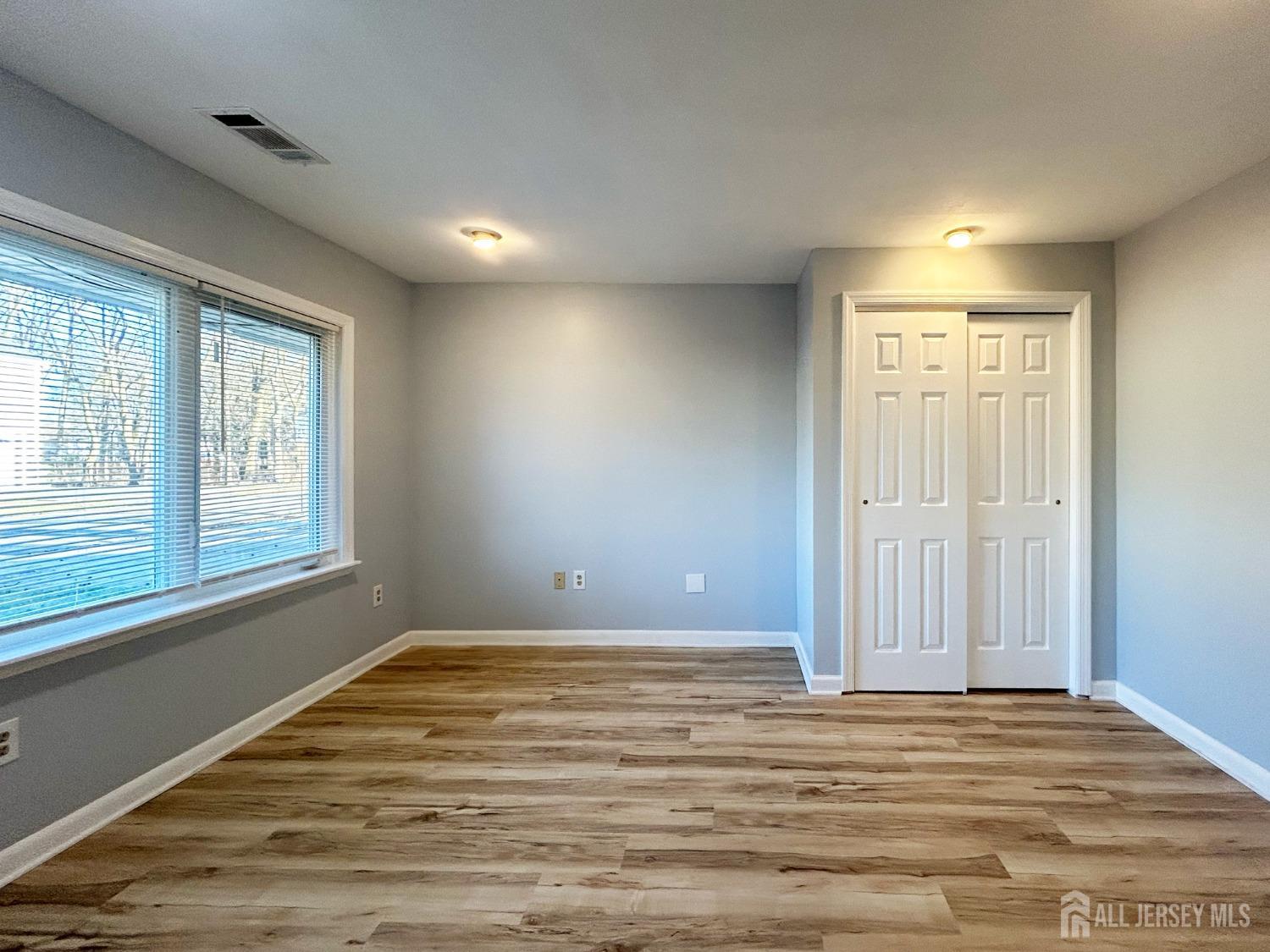 122 Vineyard Road Edison, NJ 08817 - Photo 15 of 19 a view of an empty room with wooden floor and a window