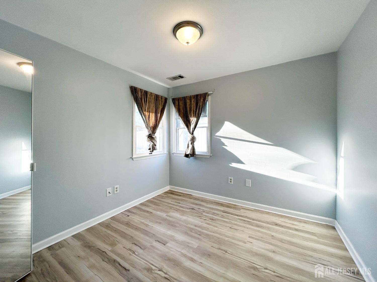 122 Vineyard Road Edison, NJ 08817 - Photo 18 of 19 a view of empty room with wooden floor and fan