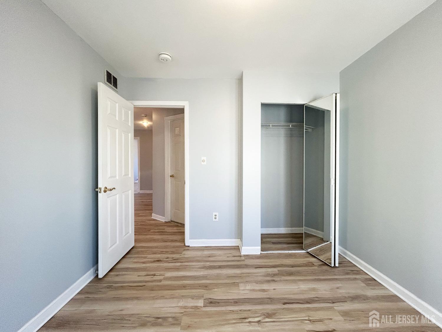 122 Vineyard Road Edison, NJ 08817 - Photo 19 of 19 a view of a hallway with wooden floor and closet area
