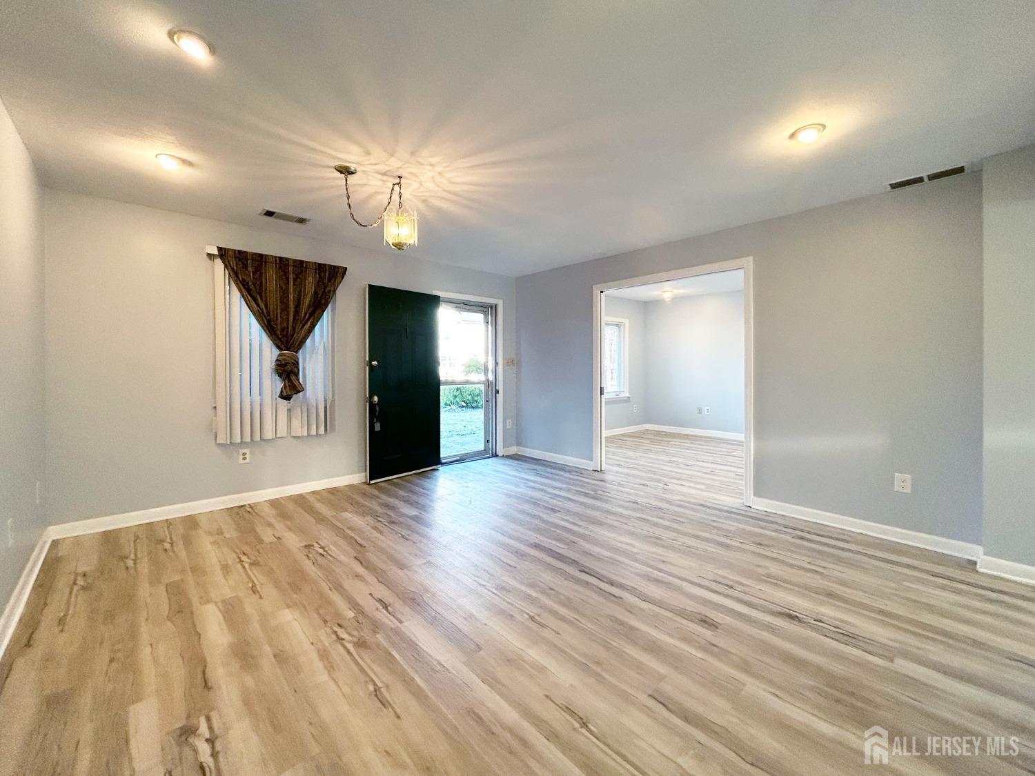122 Vineyard Road Edison, NJ 08817 - Photo 5 of 19 a view of an empty room with window and wooden floor