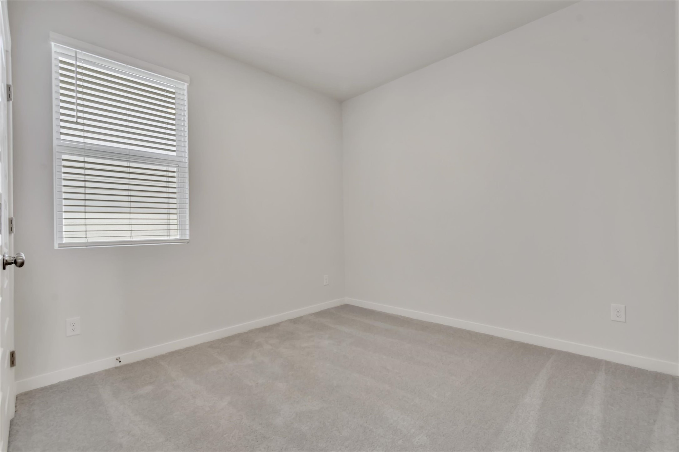 228 Bendecido Loop Elgin, TX 78621 - Photo 9 of 16 An inviting room awaits personalization, featuring a window with blinds and soft carpet flooring.