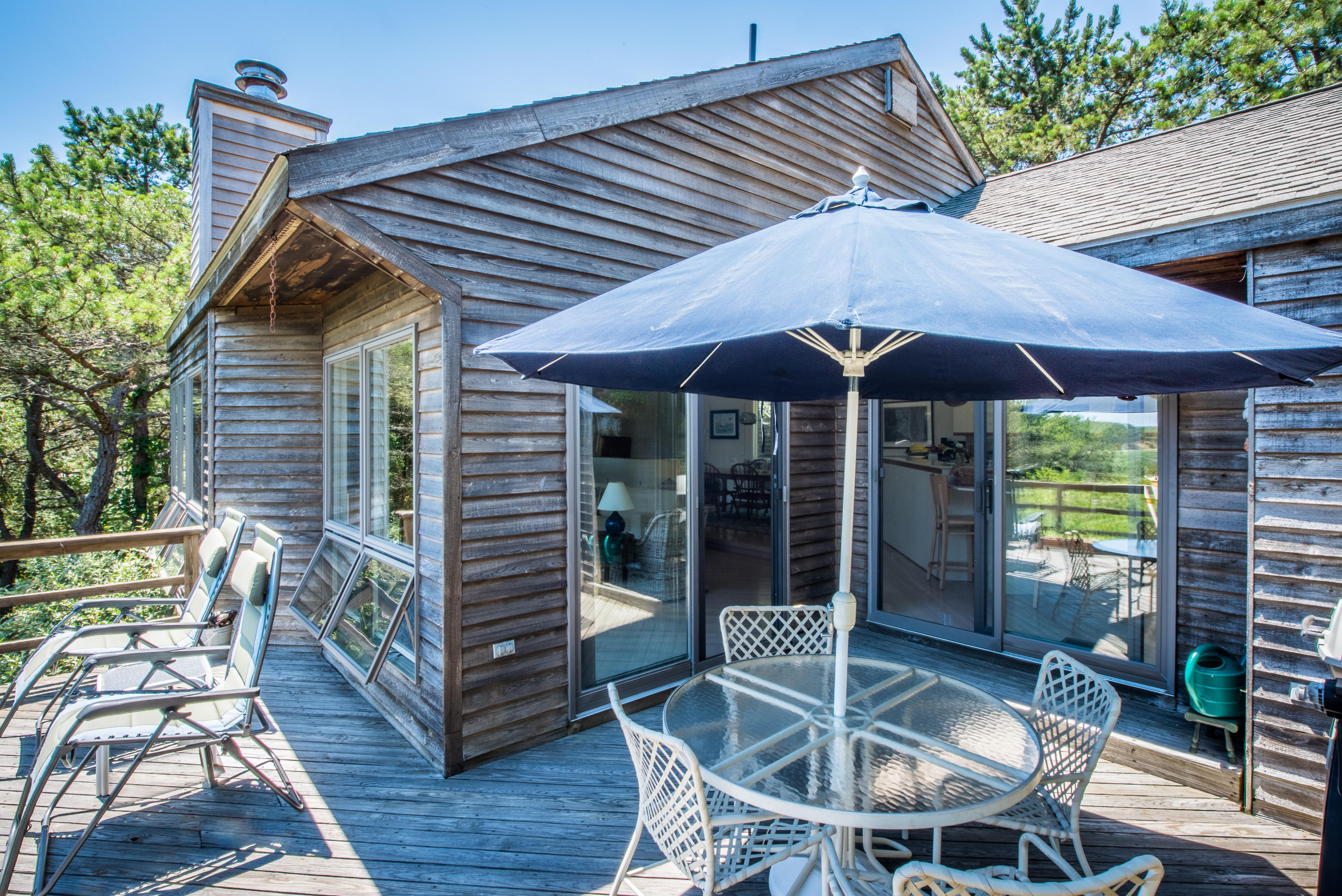 245 King Phillip Road Wellfleet, MA 02667 - Photo 30 of 33 a patio with wooden floor a yard a table and chairs