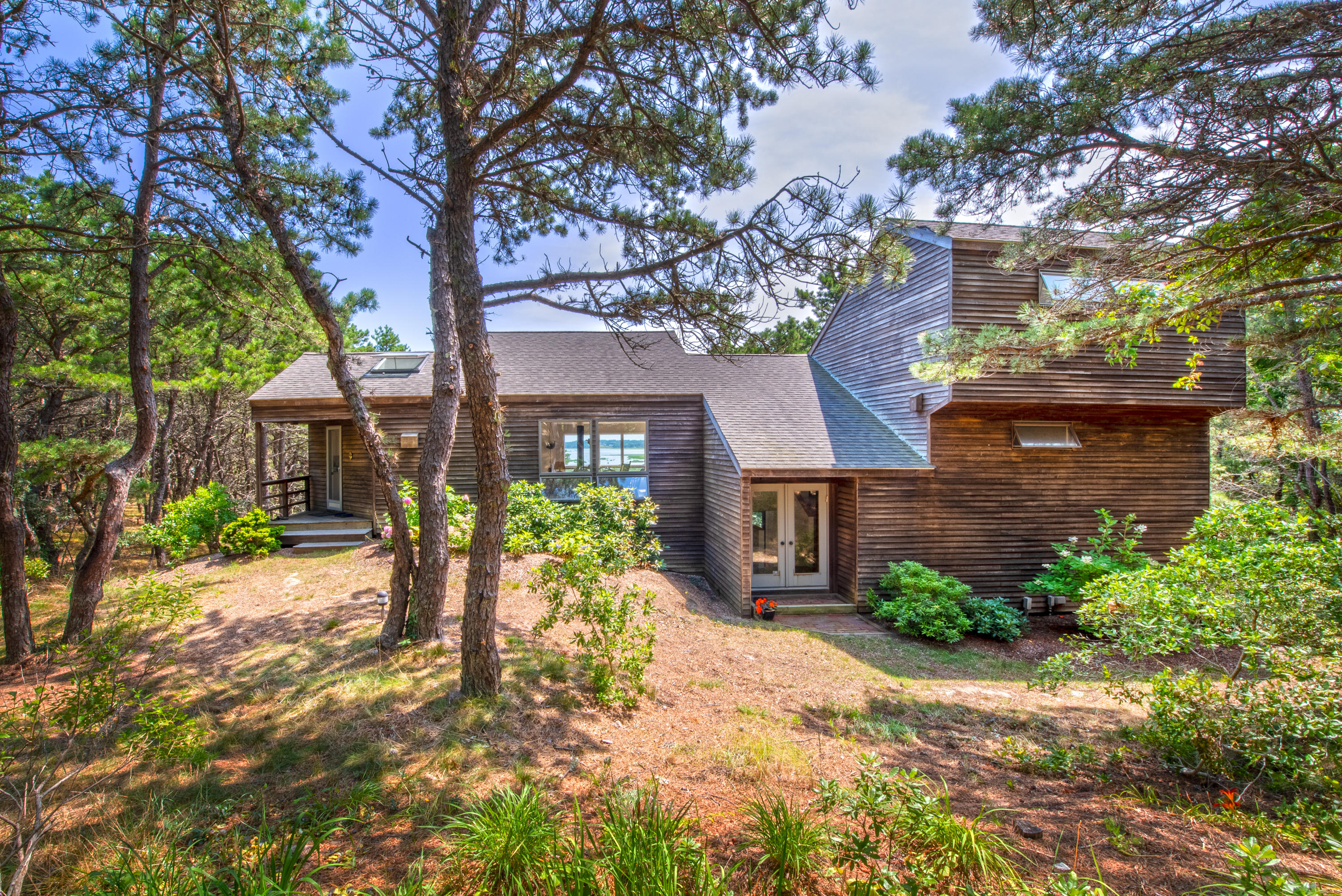 245 King Phillip Road Wellfleet, MA 02667 - Photo 3 of 33 a front view of a house with a yard and a garden