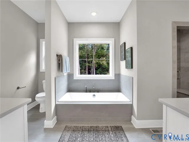 a bathroom with a tub a toilet a sink and a window