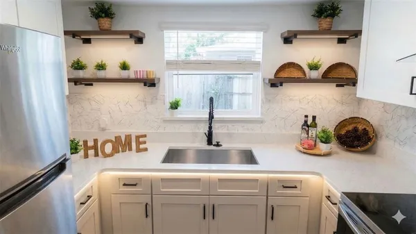 a kitchen with white cabinets and window